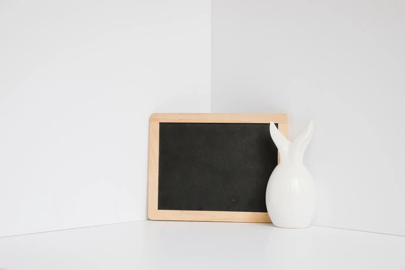 Weiße Kaninchenfigur an einer Tafel