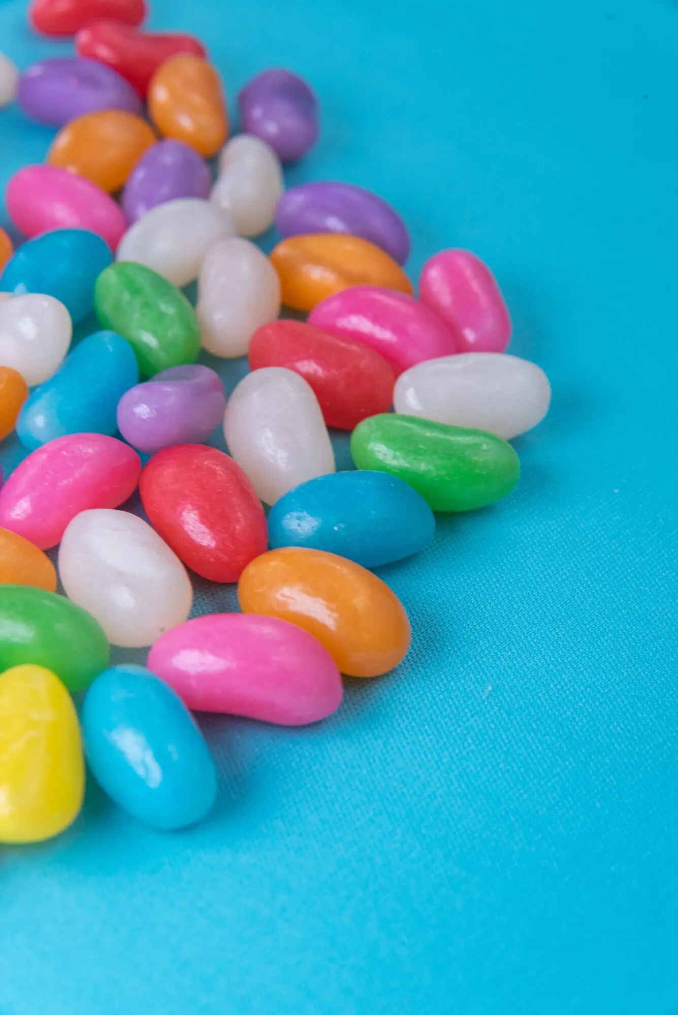 Verschiedene Jelly Beans auf blauem Hintergrund.